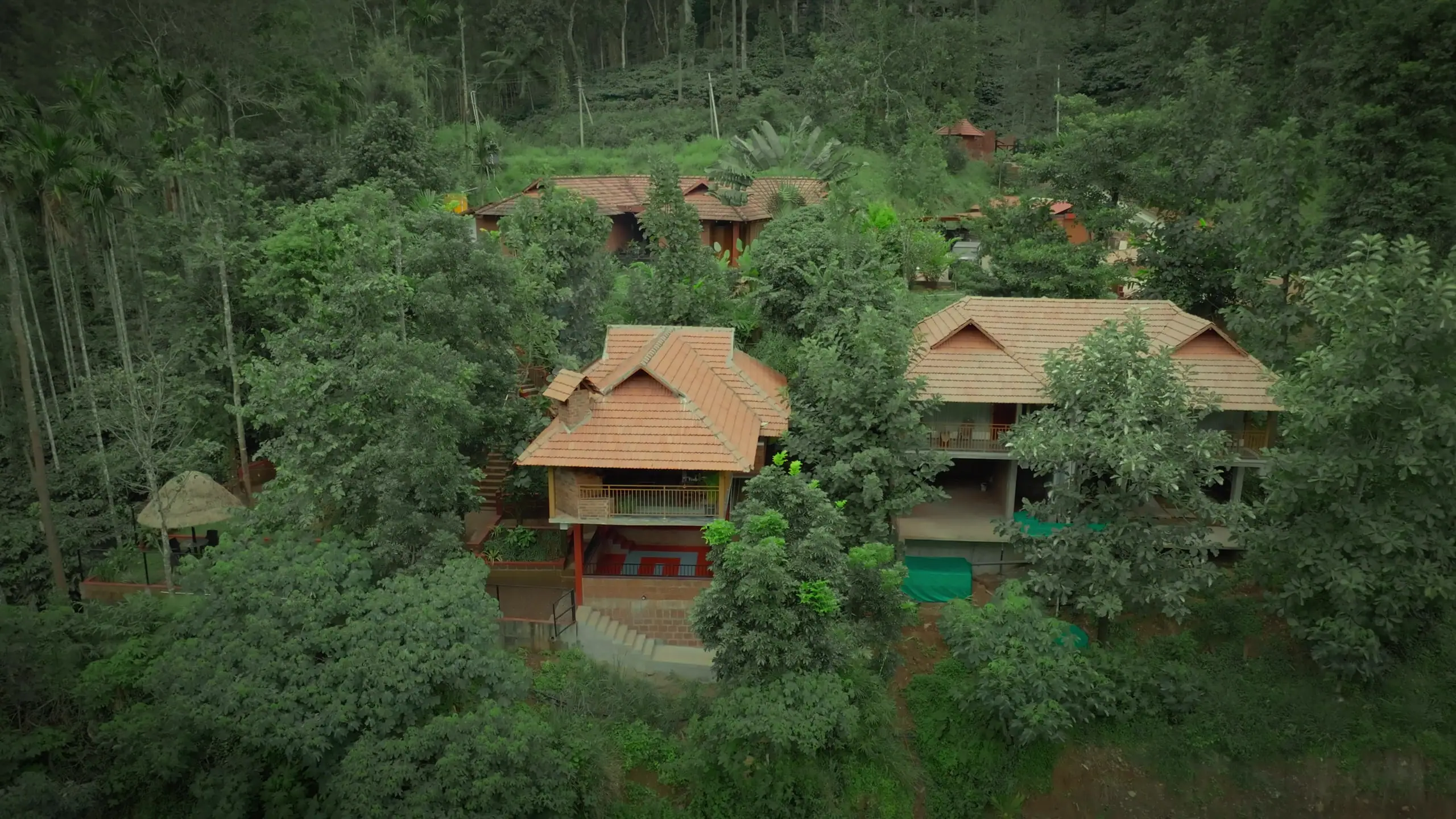 Drone view of the clay-tiled guest cottages among the estate's trees