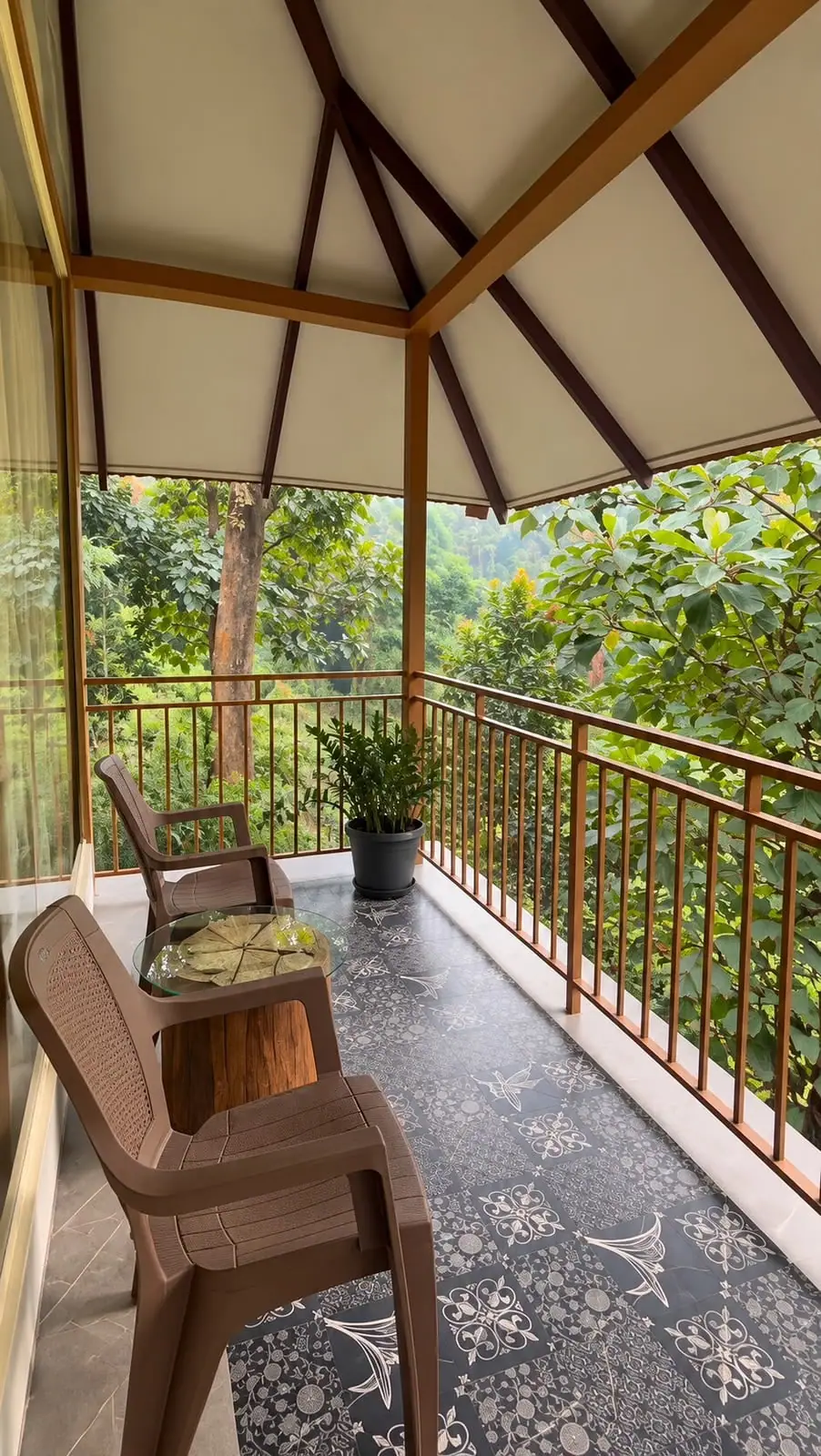 Balcony chairs at a railing, with forest falling away below