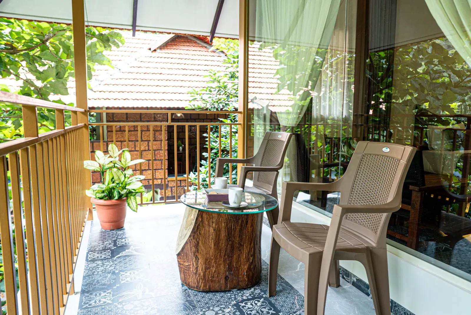 A balcony sit-out with a tree-stump table among the trees