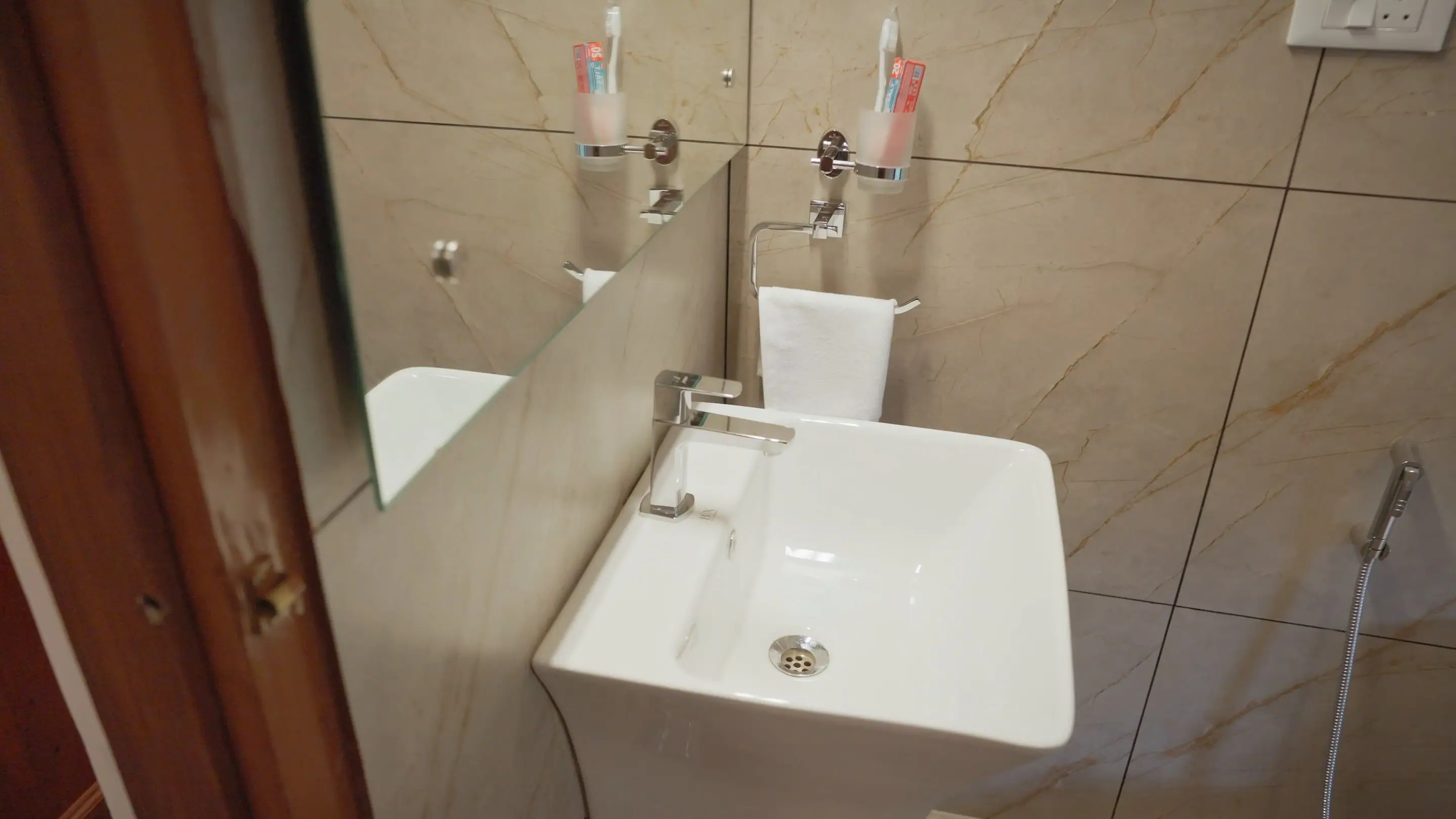 A white basin and mirror in the suite bathroom