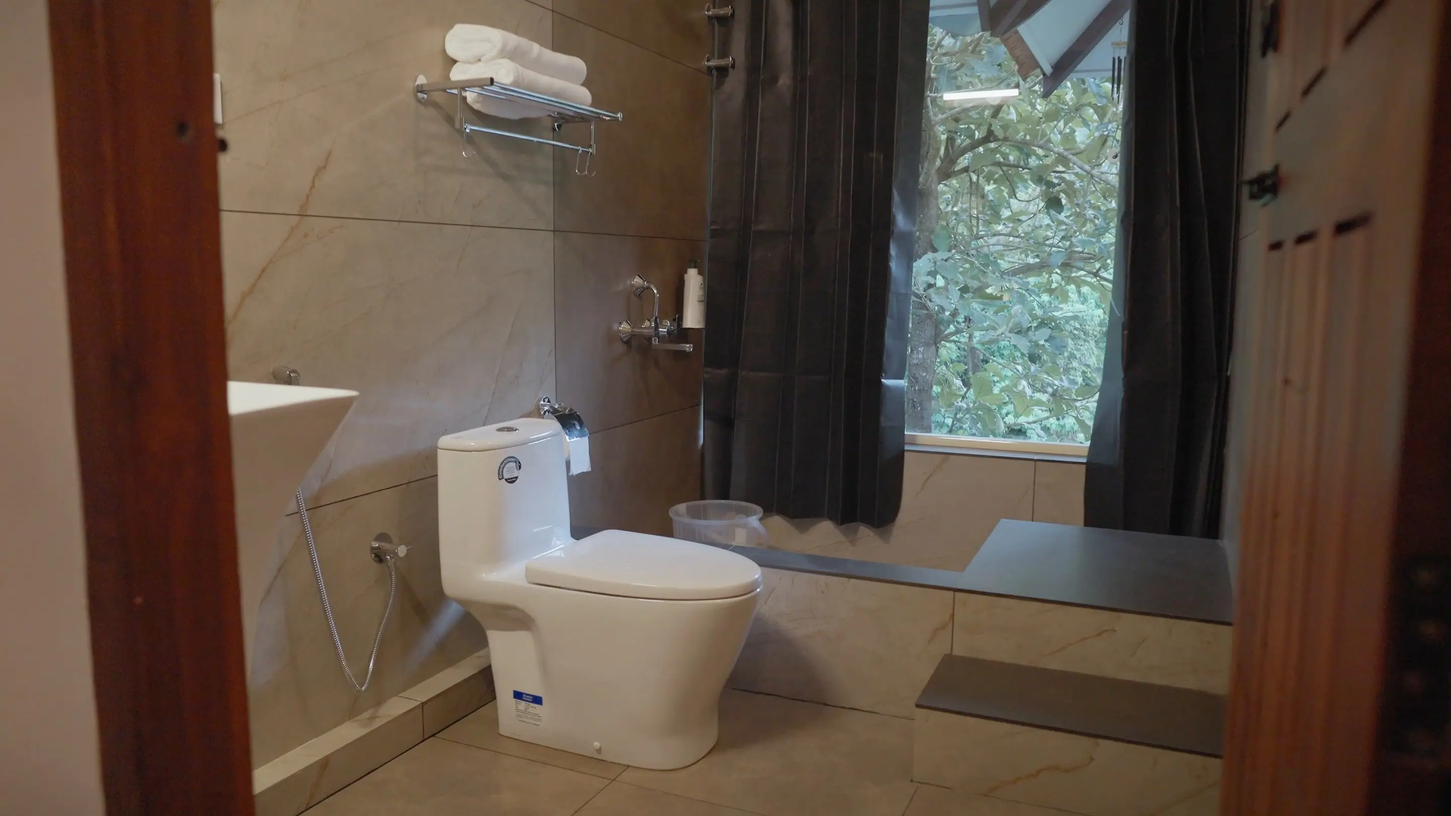 The suite bathroom, its shower window looking straight into the greenery