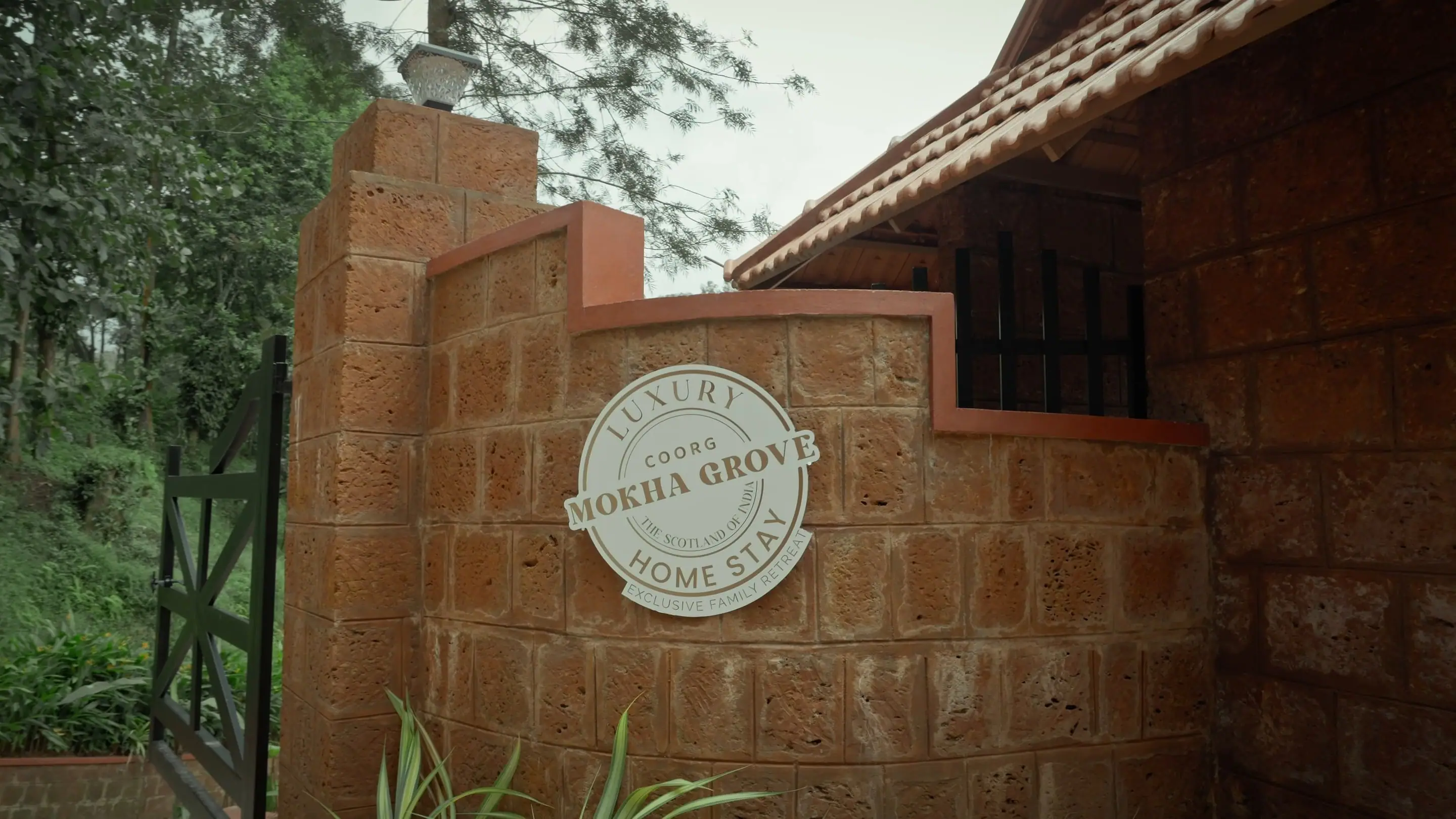 The round Mokha Grove plaque on the laterite gatepost