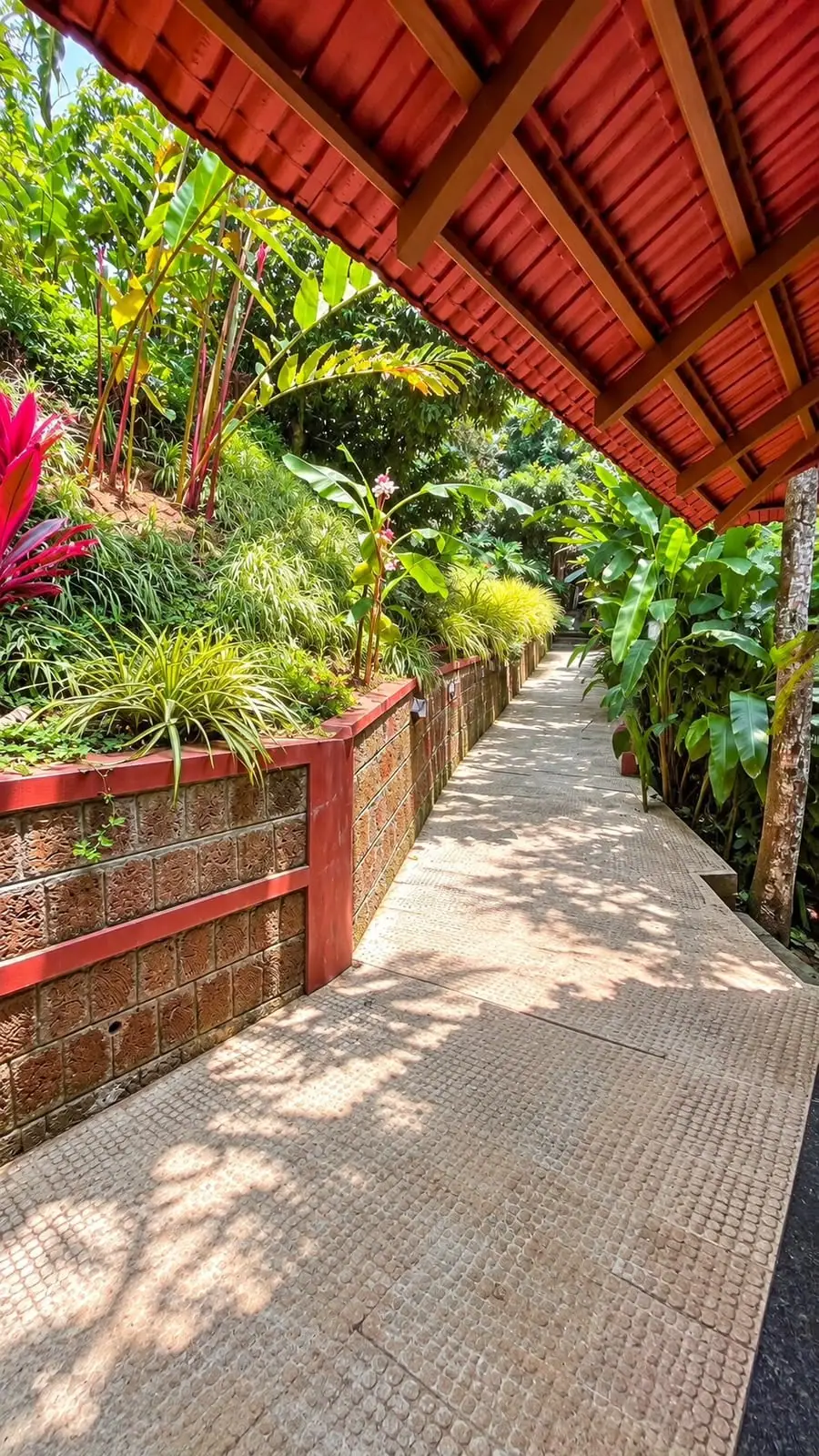 A laterite path between planted walls on a bright morning on the estate