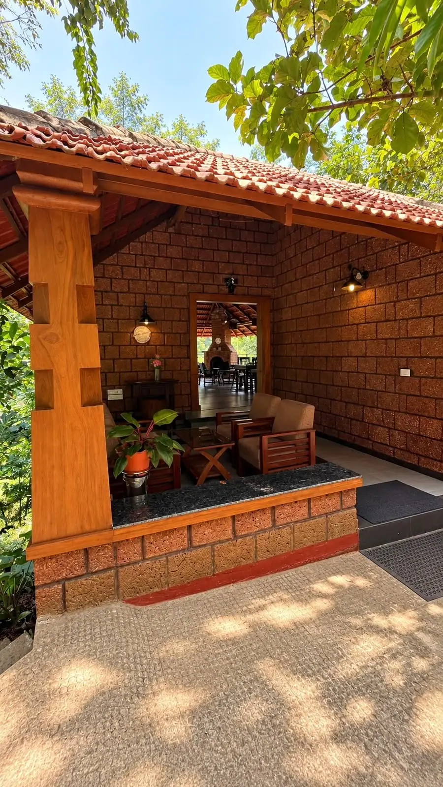 The laterite lounge with timber sofas, looking through to the dining pavilion and its fireplace