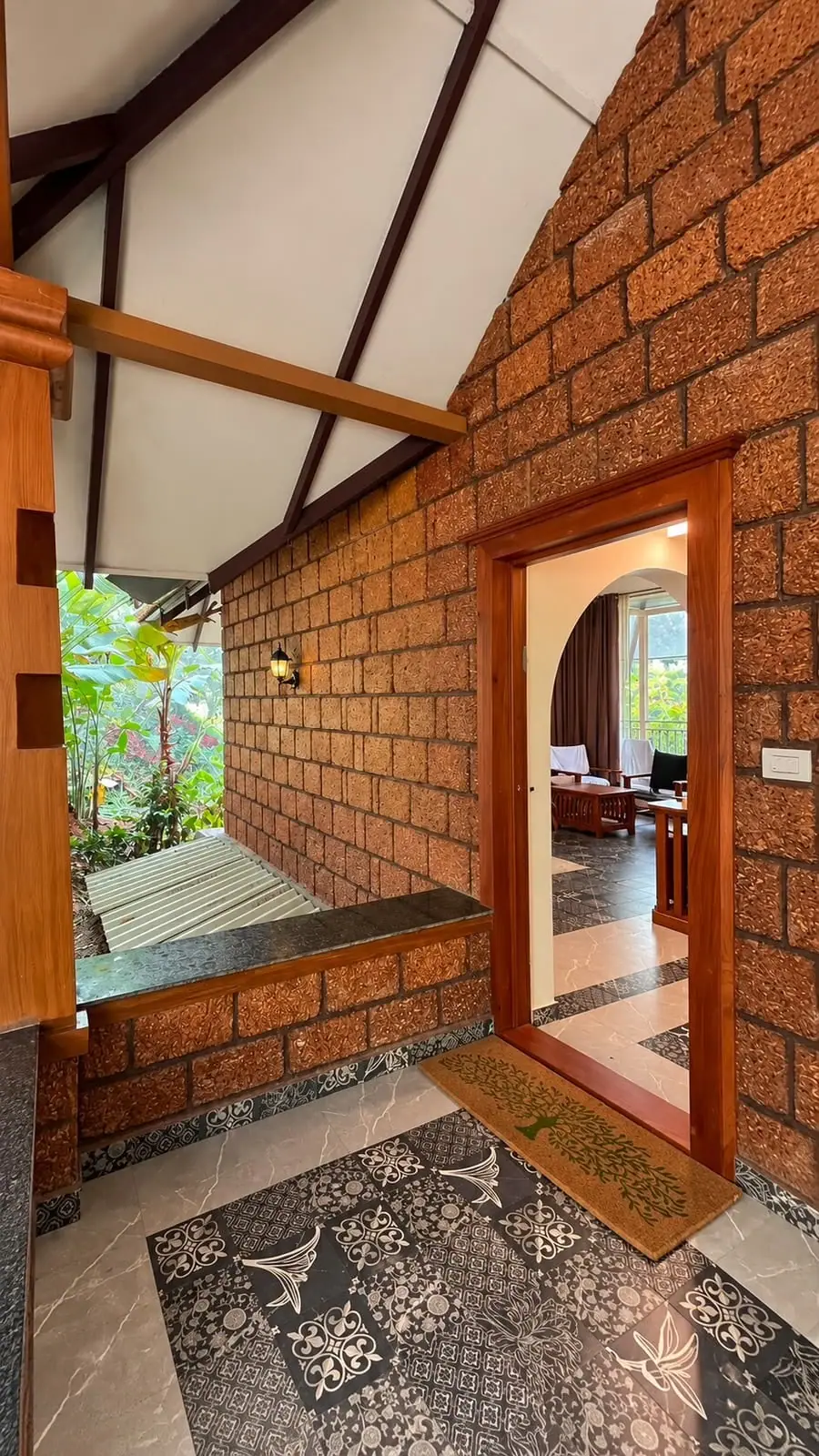 A laterite stone wall with an arched doorway opening onto the balcony