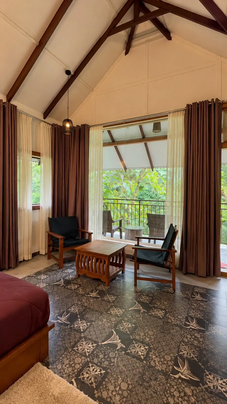 Two chairs and a timber table by the balcony doors, greenery outside