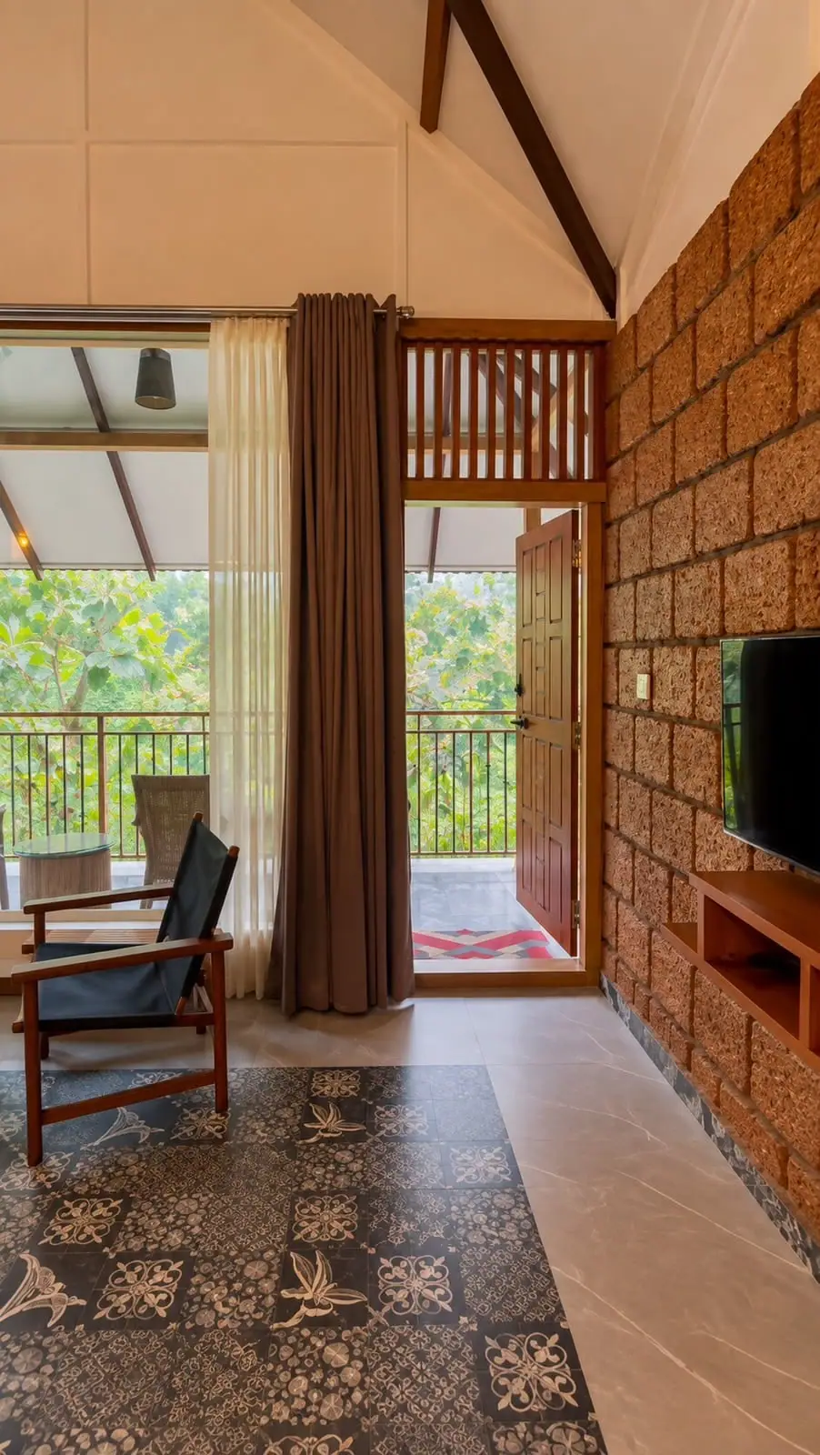 The laterite feature wall beside the open balcony door