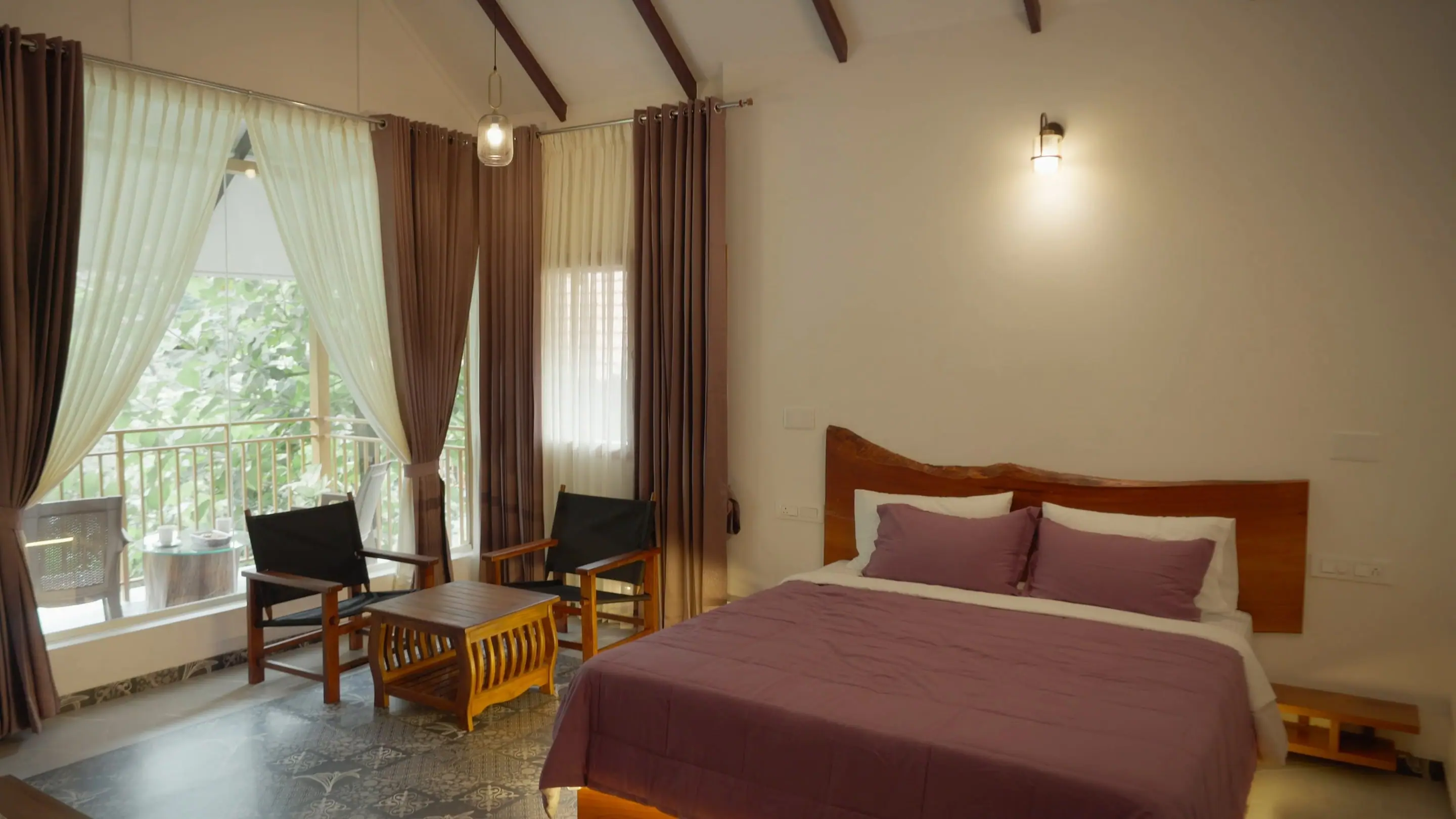 Signature Suite bedroom with tall windows onto the trees